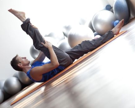 A man on an exercise mat performing mobility exercises