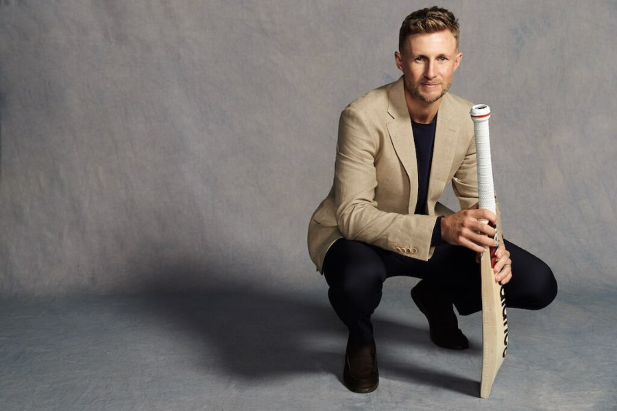 England cricketer Joe Root wears Charles Tyrwhitt jacket and squats down with cricket bat in hand