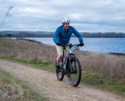 A man riding an e-bike by a lake