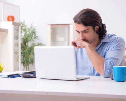 man trying to focus on his laptop at work