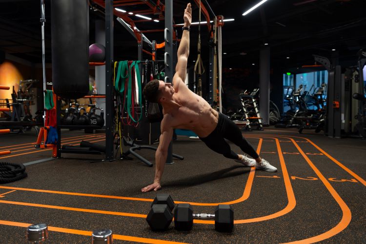 Man in a gym performing a side plank