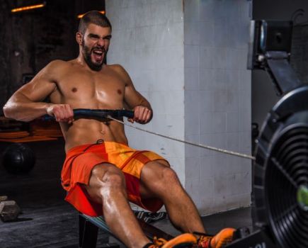 Man exercising hard on a rowing machine