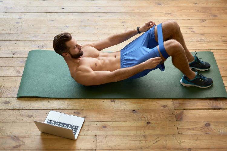 Man lying down exercising with a mini resistance band