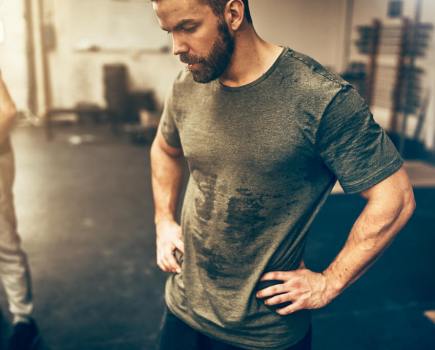 Man with hands on hips in the gym after a hard workout