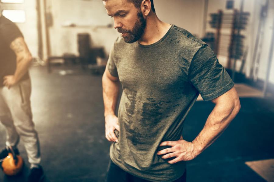 Man with hands on hips in the gym after a hard workout