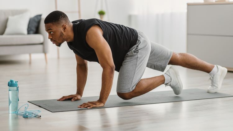 Man on a gym mat doing plank variations