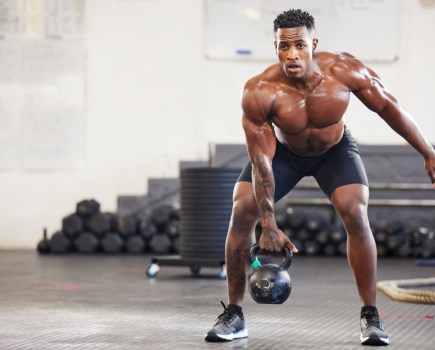 man training with kettlebell in gym workout