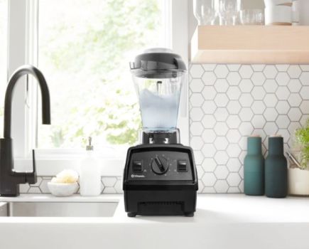 A Vitamix blender next to a kitchen sink