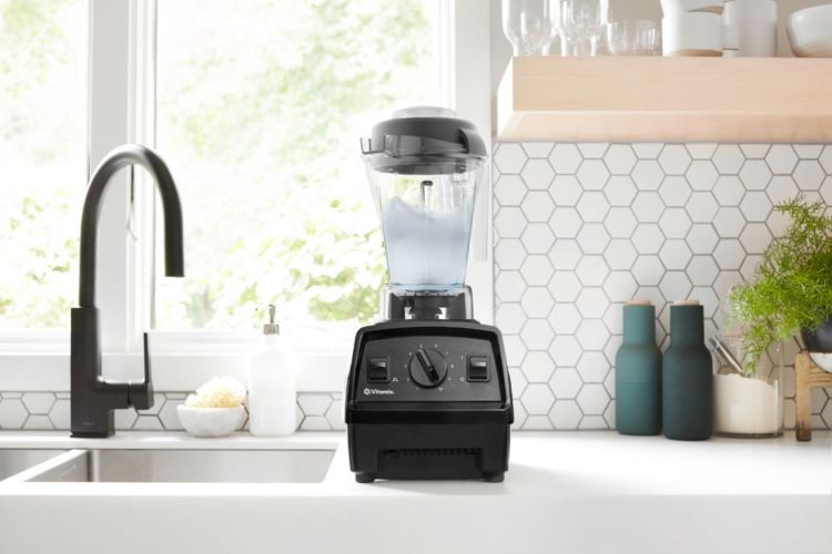 A Vitamix blender next to a kitchen sink