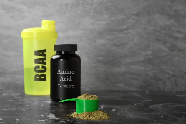 A tub and shaker with scoop of protein powder