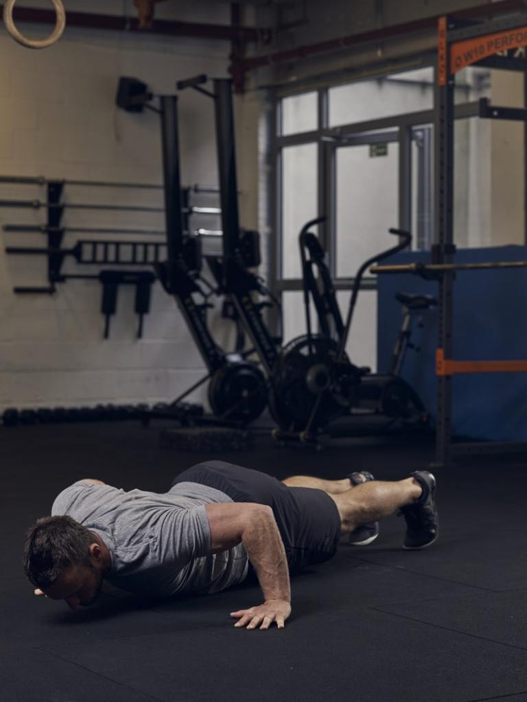 man demonstrates archer press up in gym