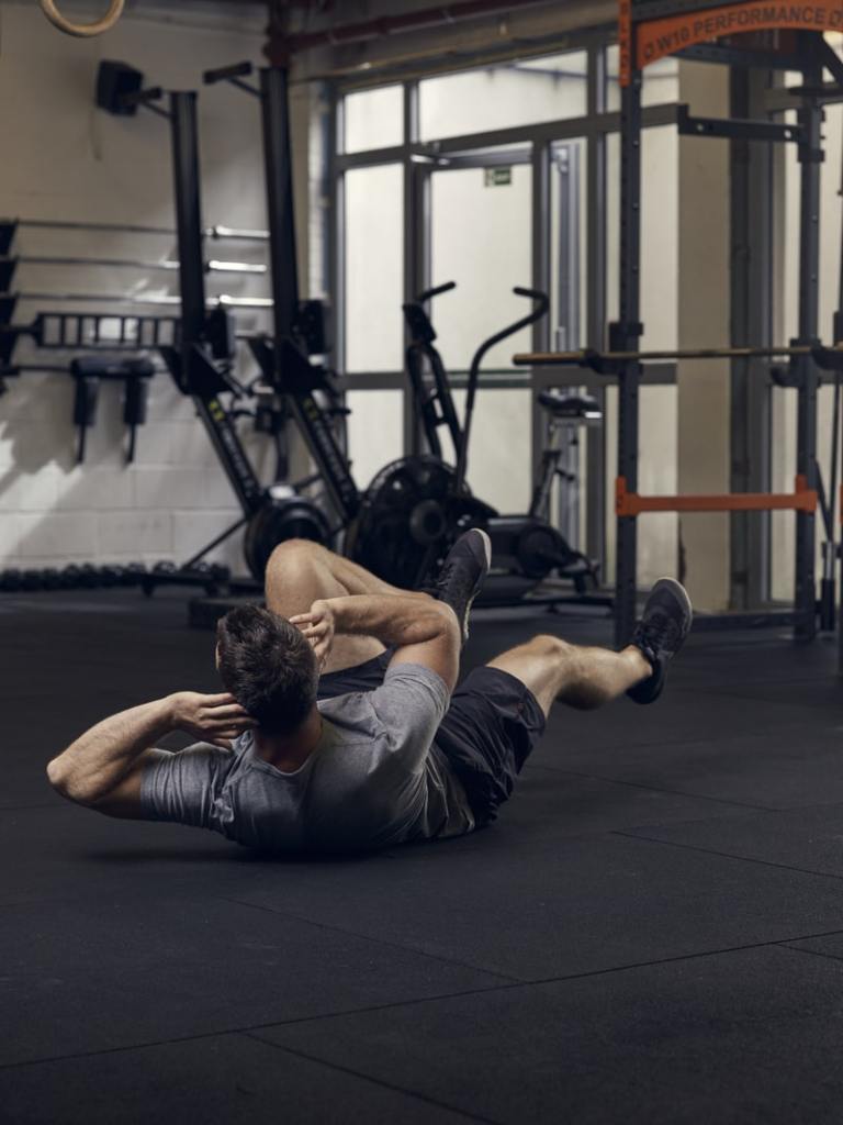 man demonstrates bicycle crunch, one of the best bodyweight exercises for core strength