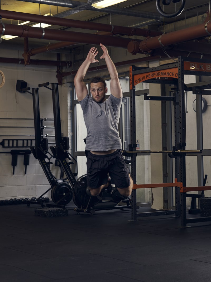man performs broad jump, one of the best bodyweight exercises for building full strength
