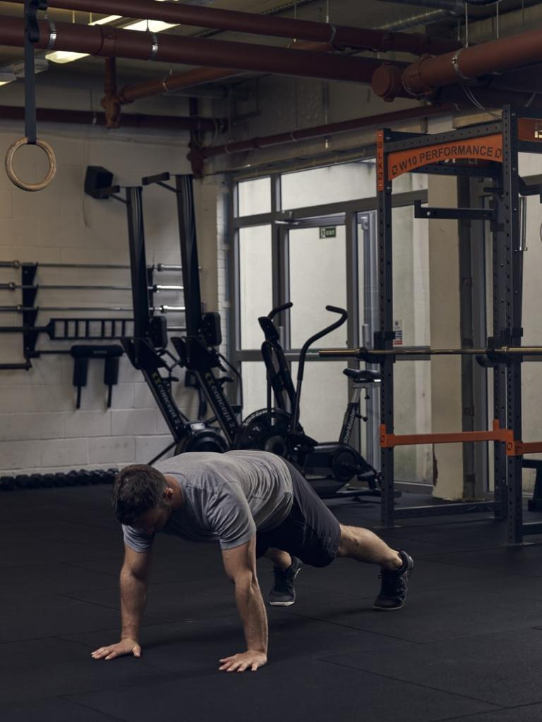 man performs part 3 of a burpee