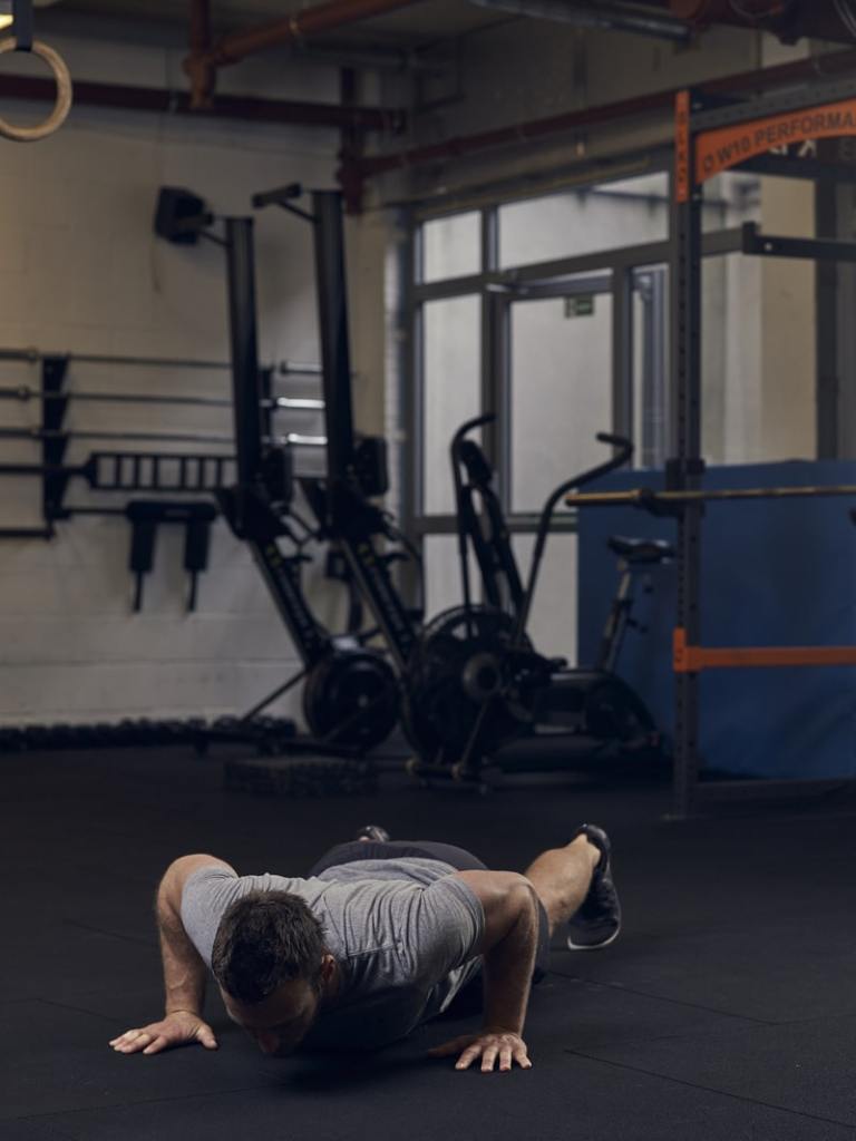 man in gym demonstrates clapping press up, one of the best bodyweight exercises to build strength