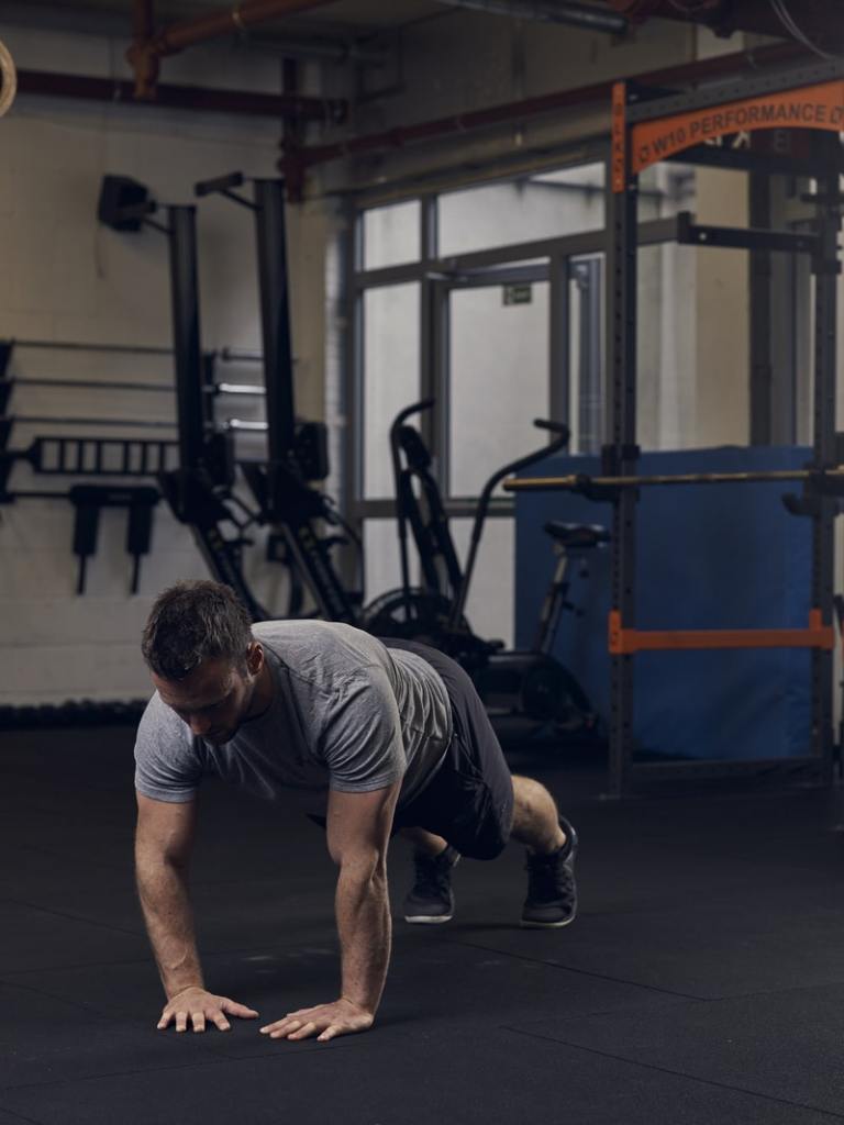 man shows how to do a diamond press up