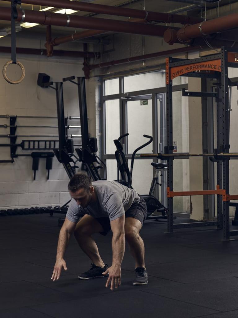 man demonstrates part 2 of half burpee