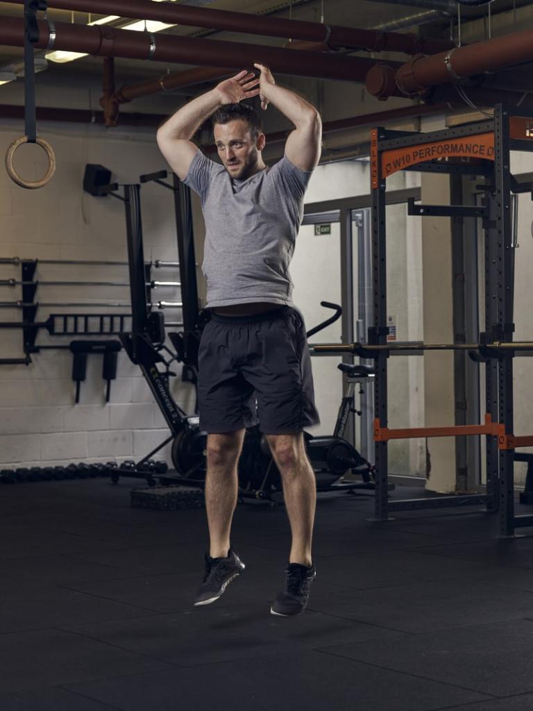 man demonstrates part 5 of half burpee