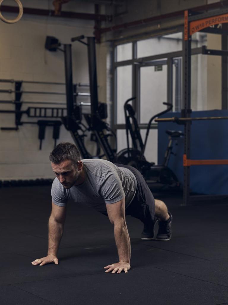 man demonstrates press up in gym