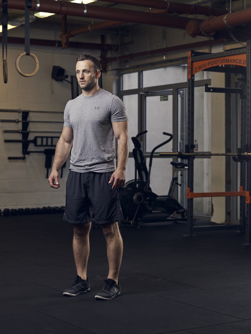 man demonstrates reverse lunge in gym