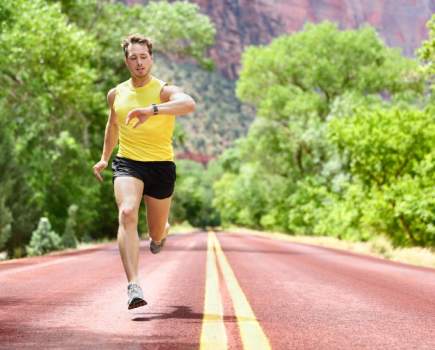 man running on road wearing 3-inch running shorts