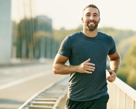 Happy man running across bridge