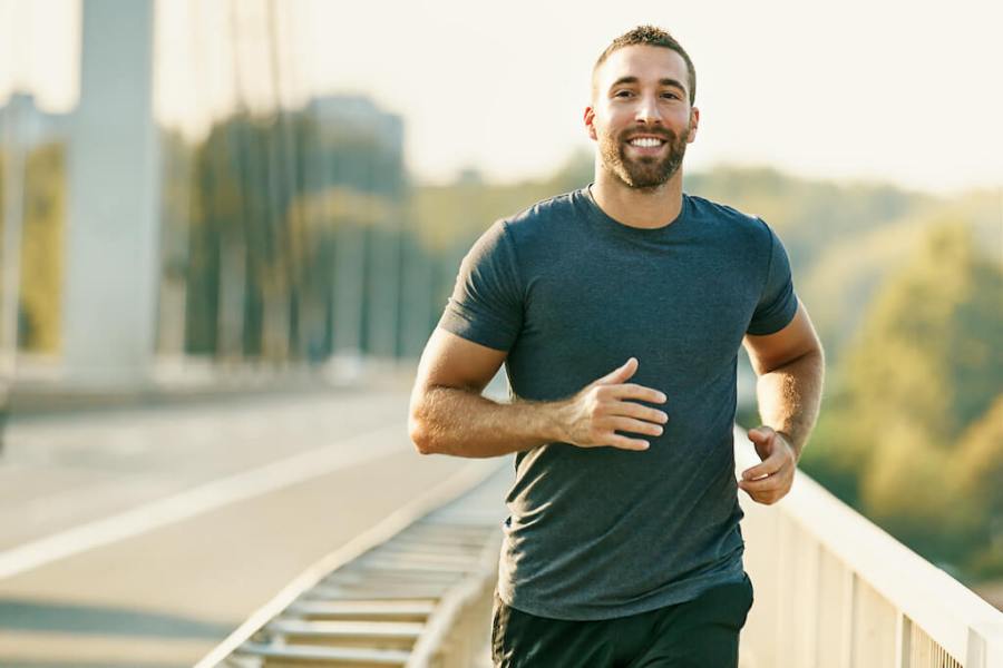 Happy man running across bridge