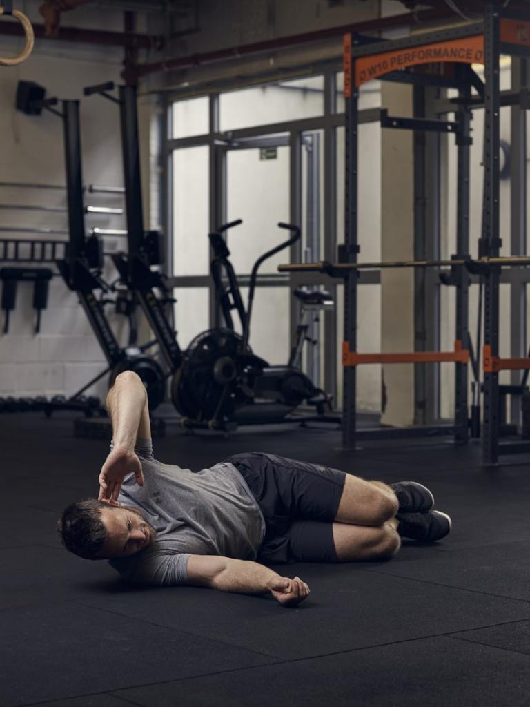 man performs side crunch