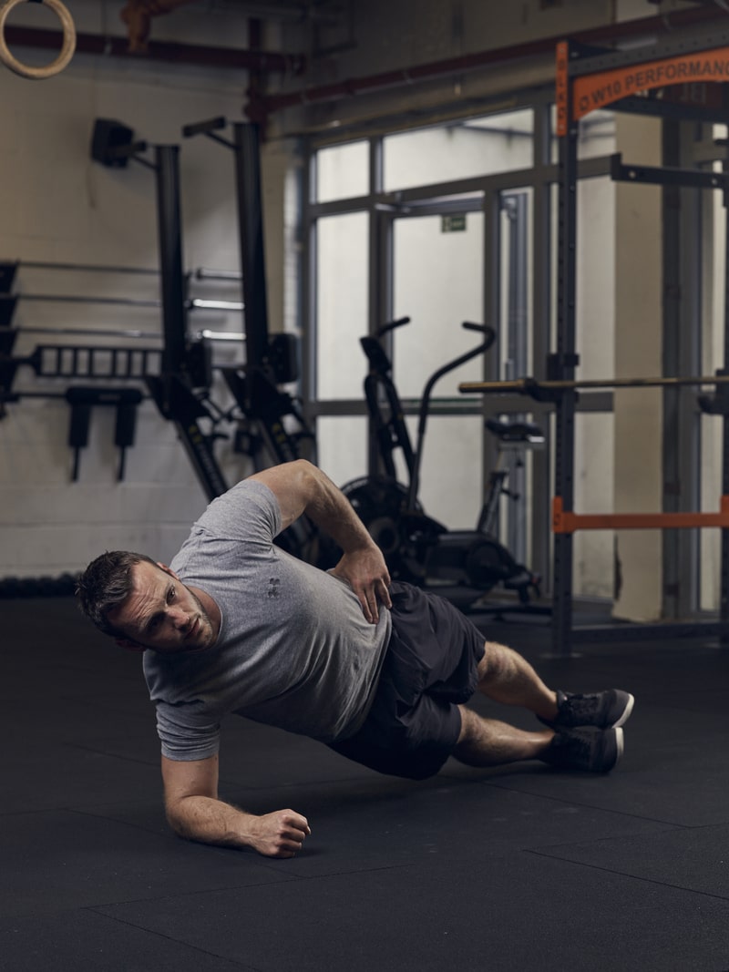 man demonstrates side plank, one of the best bodyweight exercises for core strength