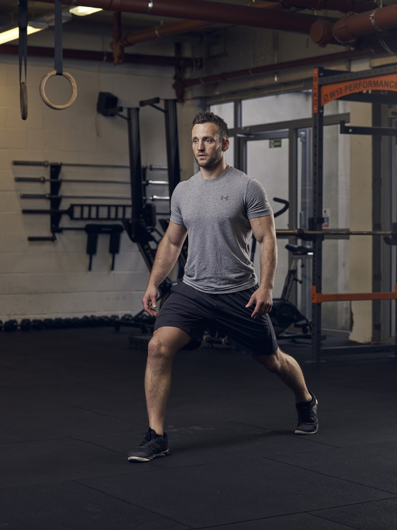 man performs split squat, one of the best bodyweight exercises for lower body strength