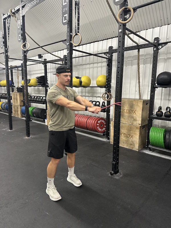 man performing band wood chop abs exercise