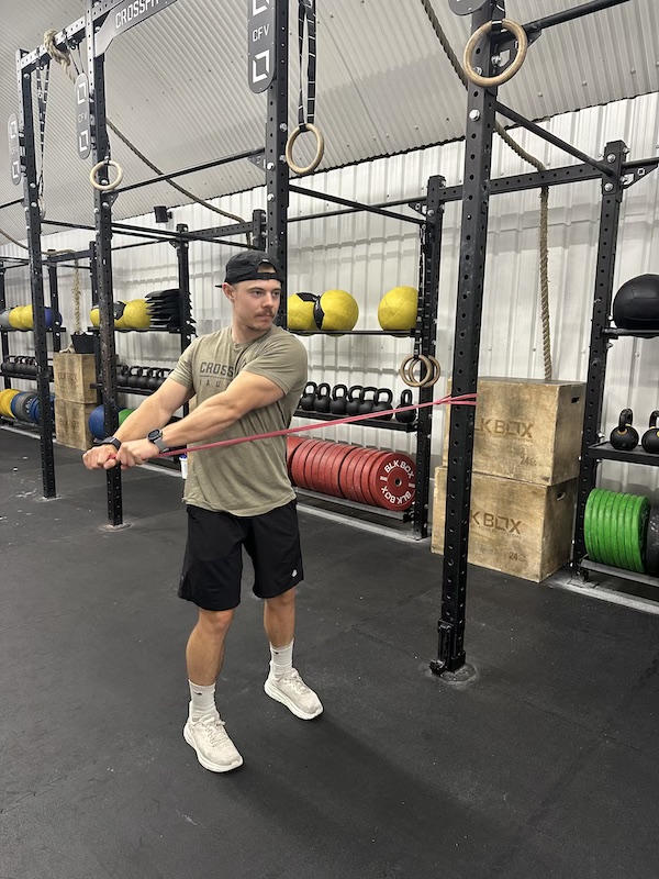 man performing band wood chop abs exercise