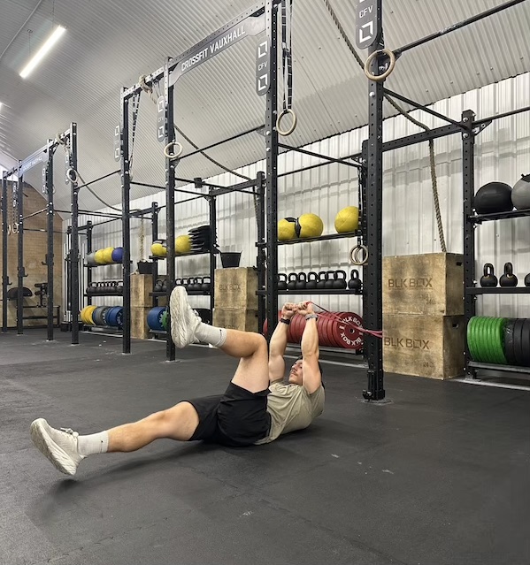 man performing band deadbug abs exercise