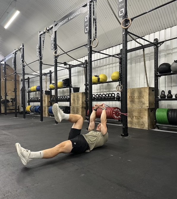 man performing band deadbug abs exercise