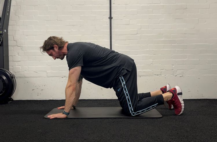 Man performing thread the needle - best back stretches