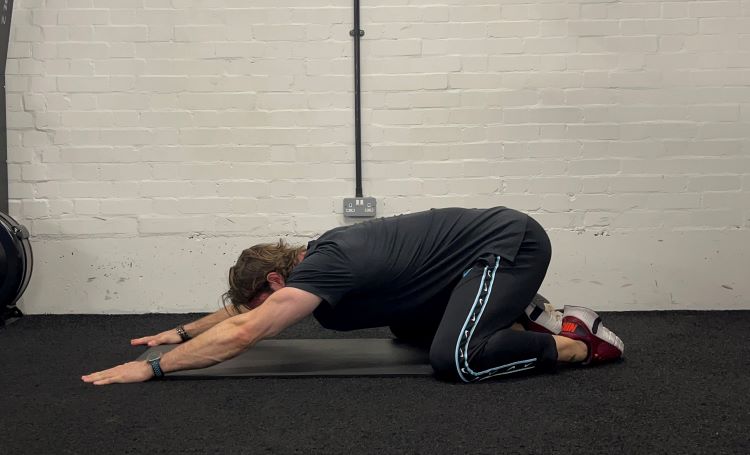 Man performing thread the needle - best back stretches