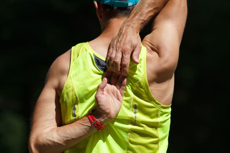 A man stretching shoulders and touching hands behind his back