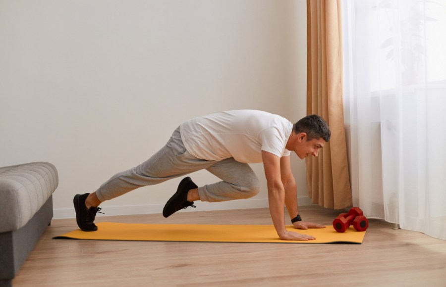 man performing abs exercises at home in sweatpants