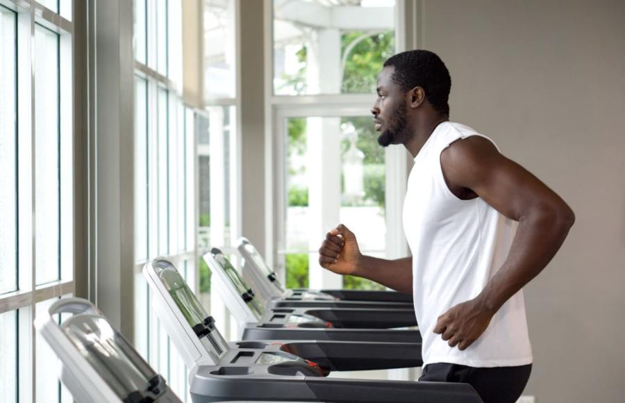 man running on treadmill for fitness and health benefits