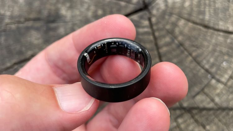 Man's hand holding an Ultrahuman Air fitness ring