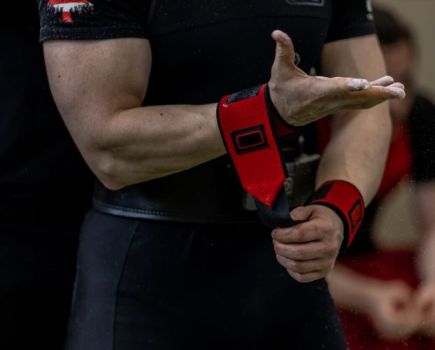 Close-up of a man putting on lifting straps