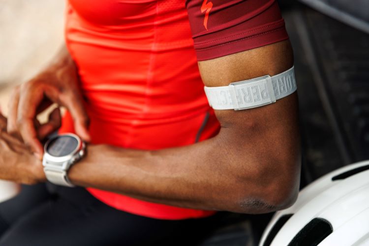 Mid torso shot of a man wearing an arm heart rate monitor