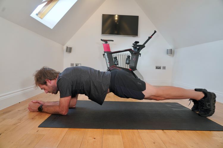 Man in home gym performing plank variations