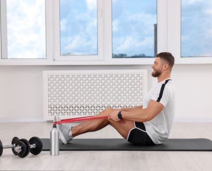 Man exercising with resistance bands and dumbbells