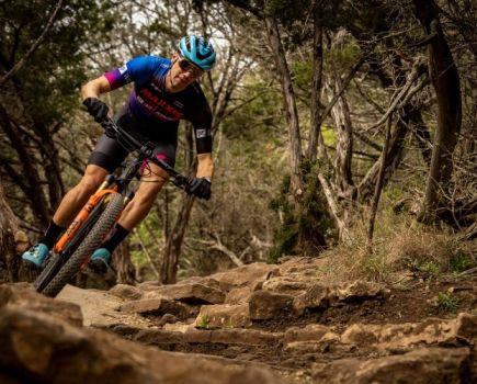 A mountain bike rider racing through the woods