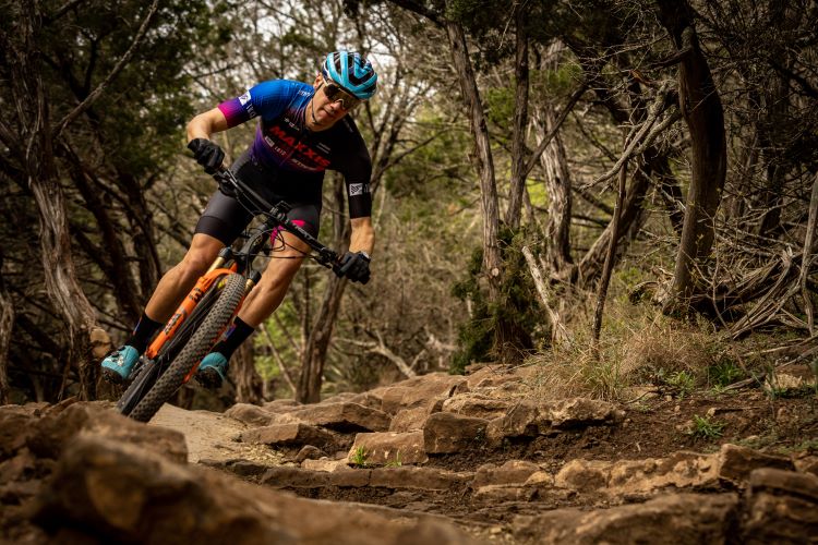 A mountain bike rider racing through the woods