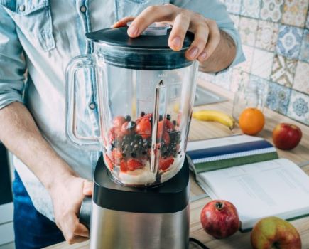 Close-up of a man using a food blender