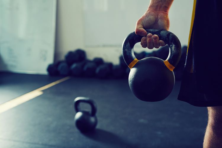 Close up of a man's hand holding a kettlebell