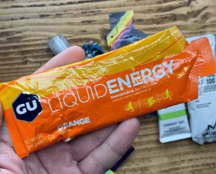 Man's hand holding an energy gel sachet