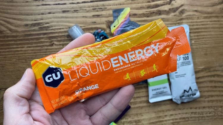 Man's hand holding an energy gel sachet